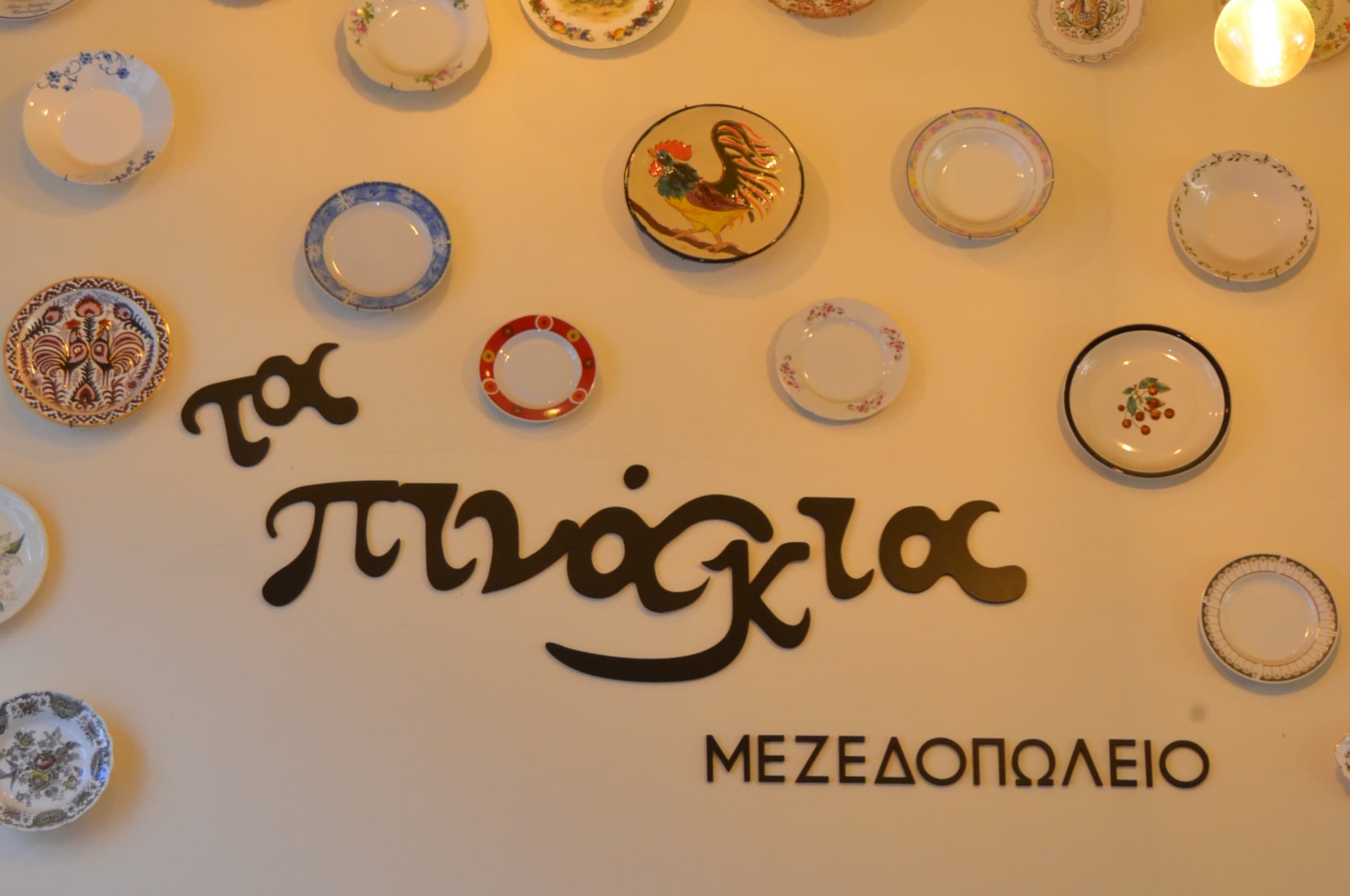 Ta Pinakia logo wall with decorative ceramic plates