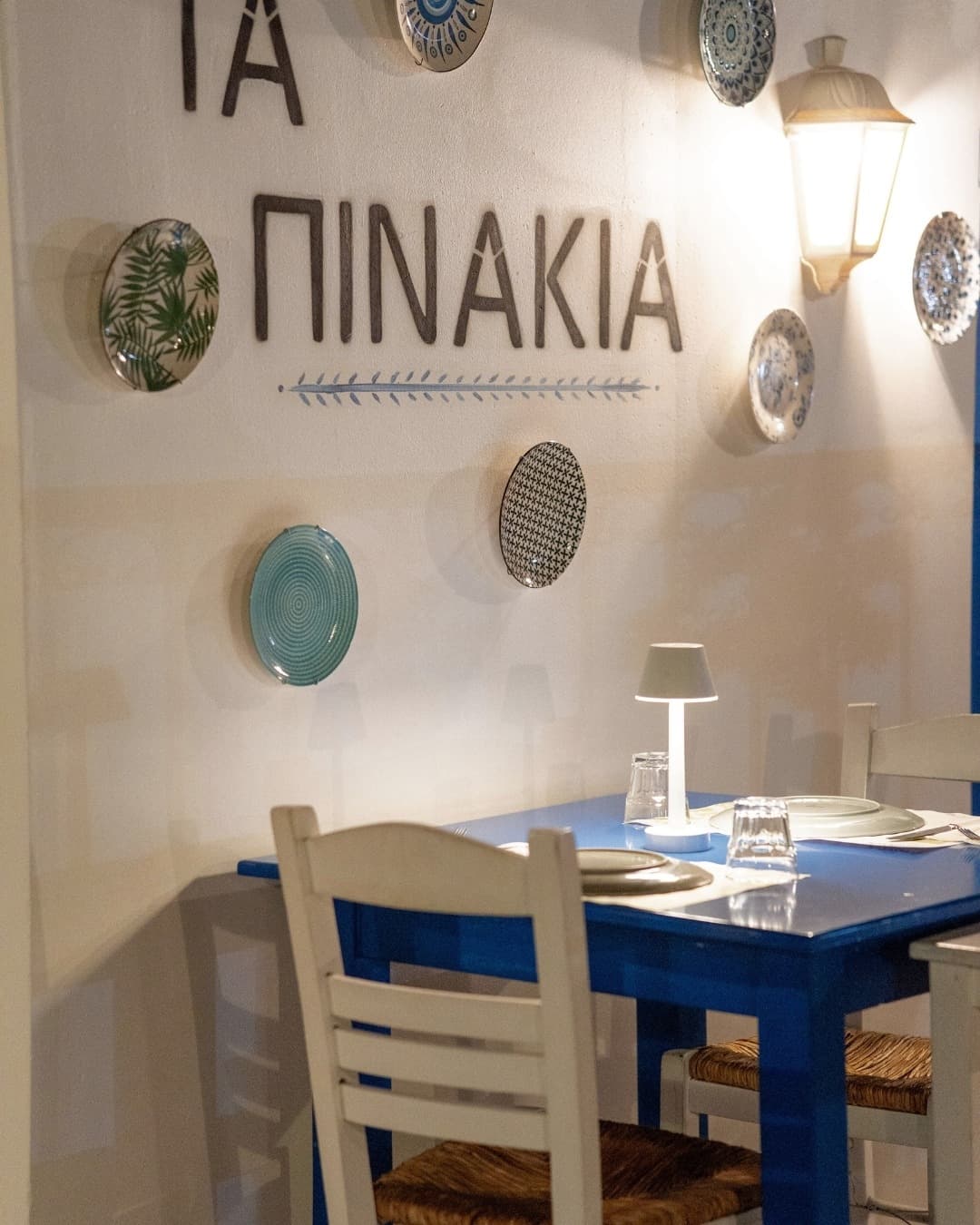 Ta Pinakia interior — blue tables and ceramic plates